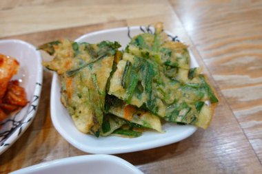 Kıtır kıtır ve lezzetli Kore Pajeon 'u ya da yeşil soğan ve çeşitli sebzelerle yapılan soğanlı krep. Lezzetli, geleneksel bir Kore yemeği. Her yemek için mükemmel..