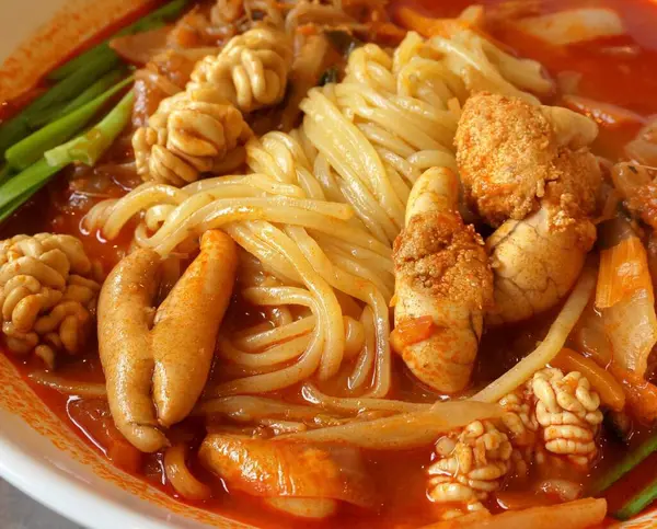 Buharı tüten bir kase jampong, baharatlı Kore-Çin erişte çorbası deniz ürünleri, sebzeler ve lezzetli et suyuyla dolu. İçten ve tatmin edici bir konfor tabağı..