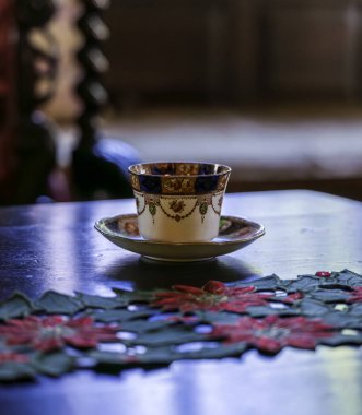 Elegant Vintage Teacup on Wooden Table with Holiday Decor in a Cozy Interior Setting clipart