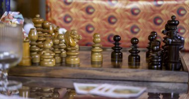 Kırsal Satranç tahtasındaki el yapımı ahşap satranç taşları. Neşeli bir arka planı var.