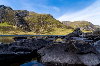 Kuzey Eryri 'deki Glyderau Dağları' ndaki Cwm Idwal 'ın Efsanevi Buz Heykeli Boşluğu' ndaki Llyn Idwal Gölü 'nün Lakeside Kayaları' nın yakınında. (Snowdonia)