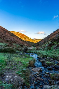 Shropshire 'ın kırsal kesimindeki Rolling Hills ve Vibrant Blue Sky ile Long Myand' deki Idyllic Stream through Carding Mill Valley