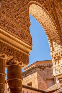 Mağripli Archway 'i parlak İspanyol Güneşi ile aydınlanan Lacy Arapça oymalarla süslemek Alhambralar Arasındaki Aslanlar Büyüleyici Mahkemesi