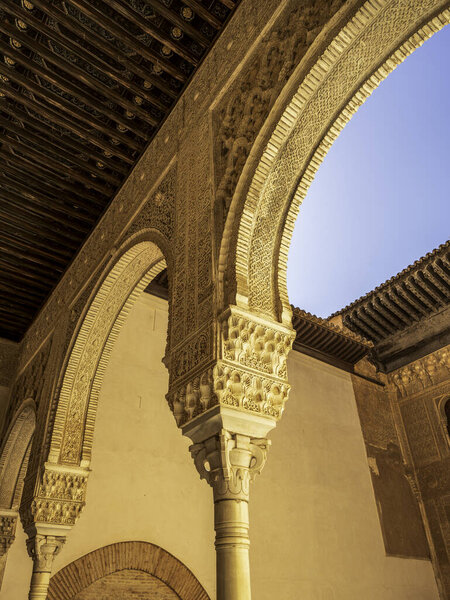 Украшенные подковообразные арки и столица Мукарнаса во дворце Комарес в Альгамбре, демонстрирующем мастерство и замысловатую андалузскую архитектуру Насрида Стукко
