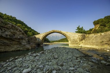 Banje Permet 'teki Ura e Kadiut (Kadiu' nun Köprüsü) Vjosa Nehri üzerindeki kemerleri, engebeli Balkan manzarasındaki Arnavut tarihini yansıtıyor