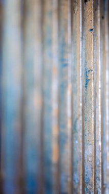 Dikey hizaya getirilmiş metal çubuklar üzerinde yapılan soğuk makro çalışma, kırık boyaları ve sığ alan derinliklerindeki ince tabakaları gösteriyor.