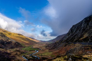 Uçsuz bucaksız vadide, dinamik bir Snowdonia gökyüzünün altında gezinen Afon Ogwen.