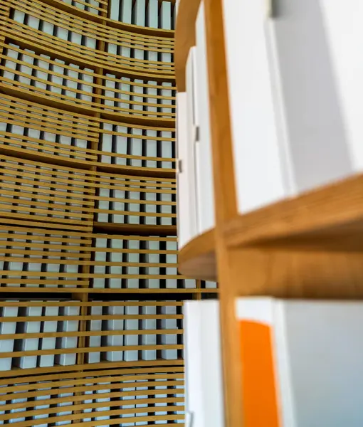 Yuvarlak huş ağacından yapılmış raflara düzgünce dizilmiş beyaz arşiv dosyalarının yakın çekimi, eğri ahşap bir zemin zeminine karşı.