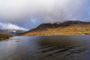 Sakin Llyn Ogwen suları sisli örtülü Glyderau yamaçlarının altında kara kara düşünen bulut örtüsünün altında