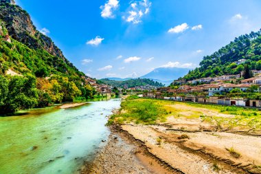 Berat 'ın zümrüt renkli Osum Nehri kumlu suları ve toprak çatılı Osmanlı evlerini sisli kireçtaşı tepelerinin altında kıvrılarak geçiyor.