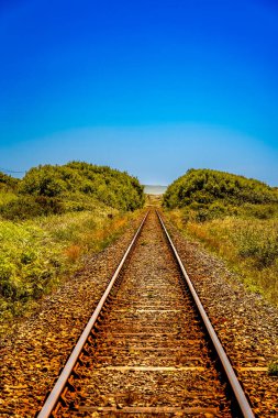 Açık bir yaz gününde Parlak Mavi Gökyüzü ile Horizon 'a giden demiryolu rayları