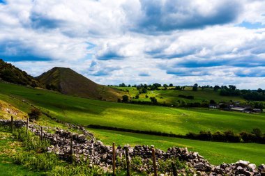 Manzaralı yeşil tepeler ve dramatik bulutların altında yuvarlanan tarım arazileri Derbyshire, İngiltere 'deki Peak District Ulusal Parkı' nda