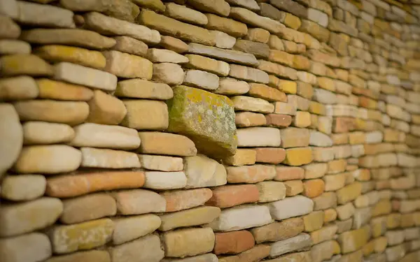 Detaylı bir taş duvar dokusu doğal bir kaya deseni ve kırsal tasarım sergiliyor, mimari projeler, arka planlar için ideal, ve doğanın bir dokunuşu..