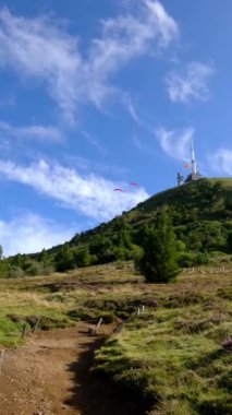Renkli Paragliderler Puy de Dome Volkanı 'nın Çimenli Yamaçlarından Uçar