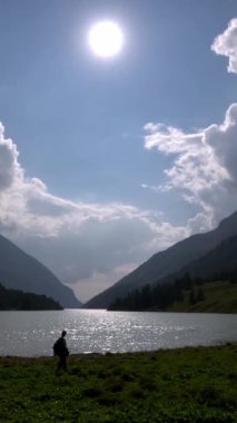 Yazın Moulin Gölü 'nde yürüyen bir kadın silueti.