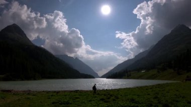 İtalya Alp Vadisi 'ndeki Moulin Gölü kıyısında yürüyen bir kadın.