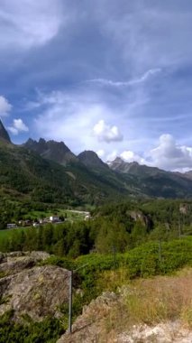 Tarihin ve dayanıklılığın ebedi özünü yakalıyor. Büyük doğal dağ manzarası içinde ayakta duran eski bir kule tarafından temsil ediliyor..