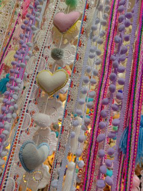 Pencerenin üzerinde çok renkli tel perdeler (lif perdesi) var. Arka planda ev bitkileri var. Seçici odaklanma. Yatay ev tasarımı arkaplanı