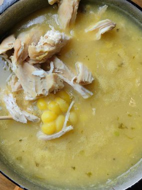 Colombian cuisine: ajiaco soup with chicken and vegetables close up in a bowl on the table. horizontal clipart