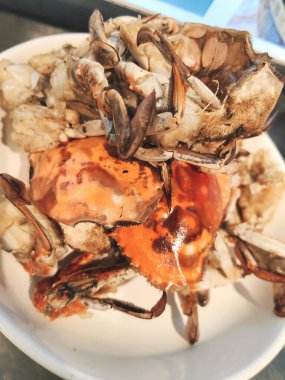 Deniz ürünleri. Beyaz şarap, limon ve bitki soslu siyah tabakta yengeç dokunaçları. Üst görünüm.