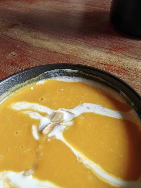 Füme domuz pirzolası ve kremalı balkabağı kreması çorbası. İki tabak yakın plan.