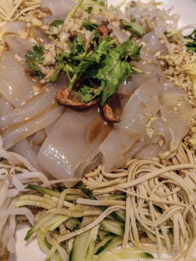 Lezzetli Asya yemeği, deniz mahsullü Asya eriştesi, siyah tabakta servis edilen karidesler.