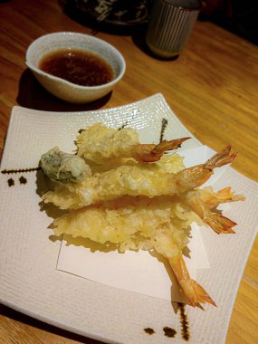 Japon usulü karidesli tempura vurucu, beyaz tabakta servis yapmaya hazır..