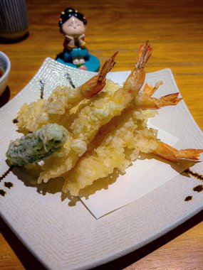 Japon usulü karidesli tempura vurucu, beyaz tabakta servis yapmaya hazır..