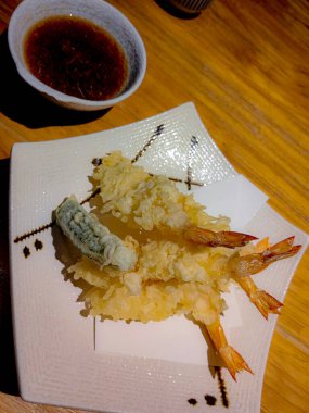 Japon usulü karidesli tempura vurucu, beyaz tabakta servis yapmaya hazır..