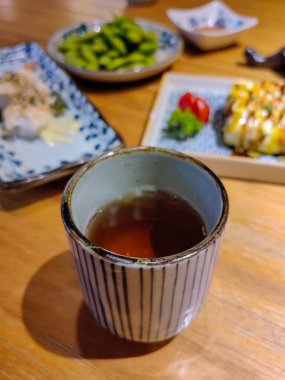 Öğleden sonra çayı, çay fincanı, tabak, yemek, çörek ve masa örtüsüyle hazırlanmış bir masanın yakın görüntüsü..