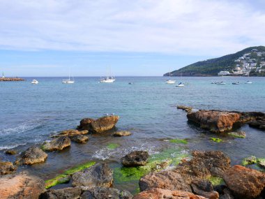 İbiza, İspanya; 2 Ağustos 2021: Mavi gökyüzü ve kristal suyla İbiza adasındaki cennet plajı.