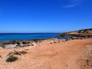 İbiza, İspanya; 2 Ağustos 2021: Mavi gökyüzü ve kristal suyla İbiza adasındaki cennet plajı.