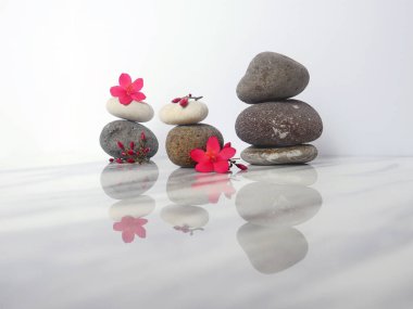 Zen taşı piramidi beyaz arkaplanda izole edilmiş çiçeklerle karıştırılmış.