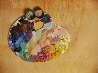 Arka planda sanat paletine yakın plan. Yağlı boyaların parlak noktaları. Metne yer var..