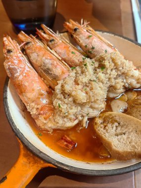 Bir tabak sarımsaklı karides ve kırmızı soslu ekmek. Akdeniz mutfağı.