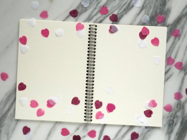 Pembe kitap ya da günlük defterinde kırmızı kalpler parlıyor..