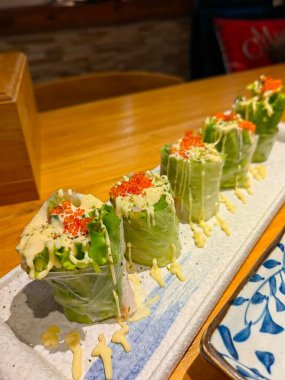 Porsiyon olarak Asya böreği, sebze, baharatlı soslu eski ahşap tabakta domuz eti.