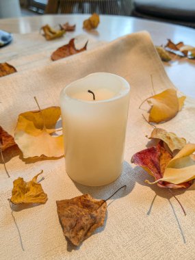 Sonbahar tonları ve yaprakları, çiçek ve mum yemek masası için idealdir..