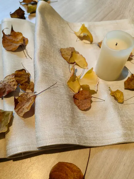 Sonbahar tonları ve yaprakları, çiçek ve mum yemek masası için idealdir..