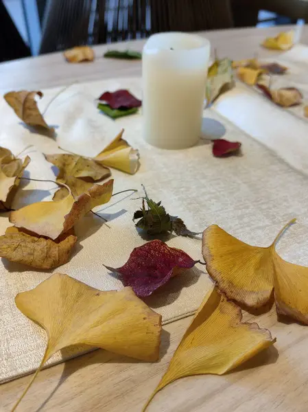 Sonbahar tonları ve yaprakları, çiçek ve mum yemek masası için idealdir..