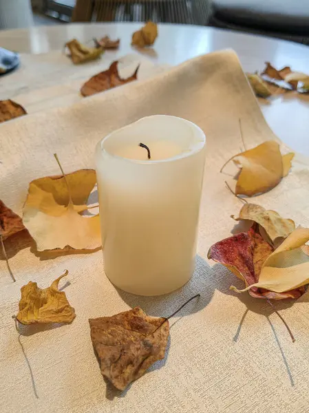 Sonbahar tonları ve yaprakları, çiçek ve mum yemek masası için idealdir..