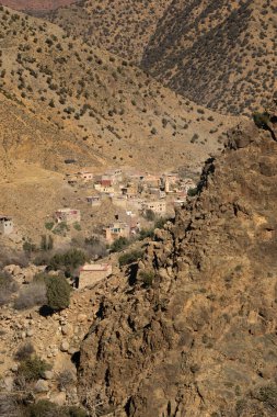 Arka planda köyü olan bir dağ. Dağ kahverengidir. Atlas Dağları. Fas