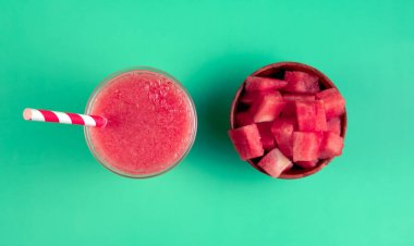 Bir bardak karpuz suyu ve bir kase karpuz küpü. Serinleme ve yaz mevsimi kavramı