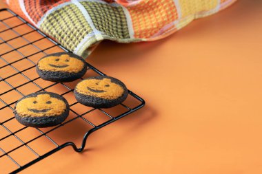 Sonbahar renkli kareli peçeteli soğutma rafında üç tane karanlık Cadılar Bayramı Jack-o 'fener kurabiyesi yakın plan.