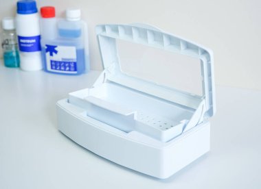 Güzellik ve tıbbi aletleri dezenfekte etmek için açık kapaklı beyaz plastik sterilizasyon kutusu.