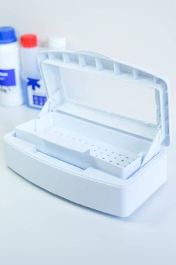Güzellik ve tıbbi aletleri dezenfekte etmek için açık kapaklı beyaz plastik sterilizasyon kutusu.
