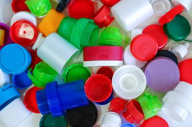Renkli plastik kapaklar ve kapaklar, geri dönüşüm ve atık sıralaması için mükemmel bir kavram..