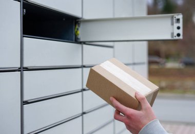 Açık bir paket teslimatı ya da paket alımının yanında karton kutuyla bir elin yakın çekimi