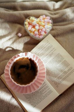 Bir fincan sıcak kahve, bir kitap ve tatlı şekerlemeler rahatlatıcı bir an için mükemmel.