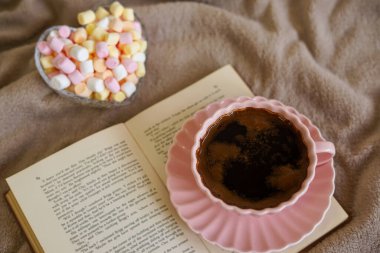 Bir fincan sıcak kahve, bir kitap ve tatlı şekerlemeler rahatlatıcı bir an için mükemmel.
